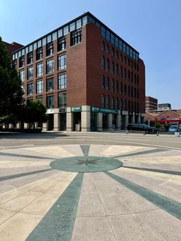 A brick office building next to a compass rose in Hexi District, Tianjin, China.