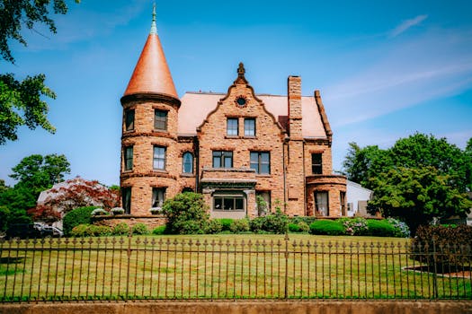 Beautiful historic brick mansion with a unique tower and lush gardens.