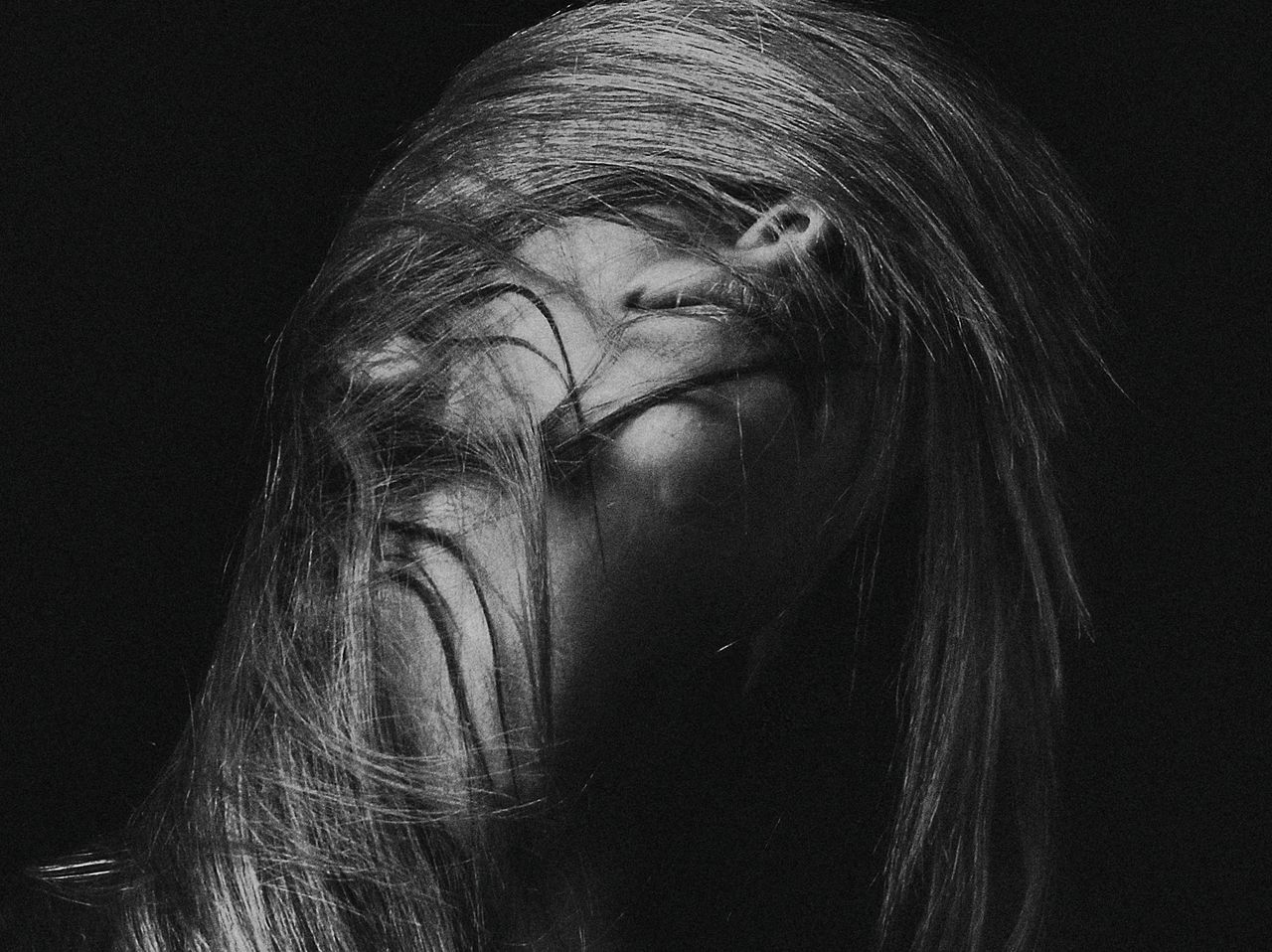 artistic black and white portrait capturing dynamic hair movement of a
