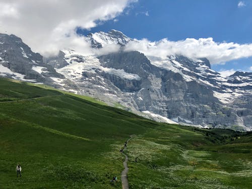 Champ Vert Vue Sur La Montagne Sous Un Ciel Bleu Et Blanc