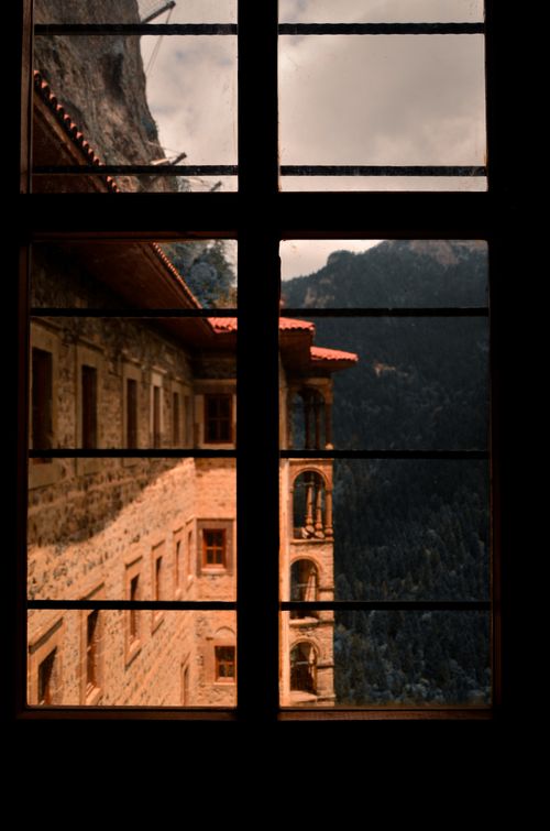 Free Captivating view of a historic fortress through a rustic window, with scenic mountains in the background. Stock Photo