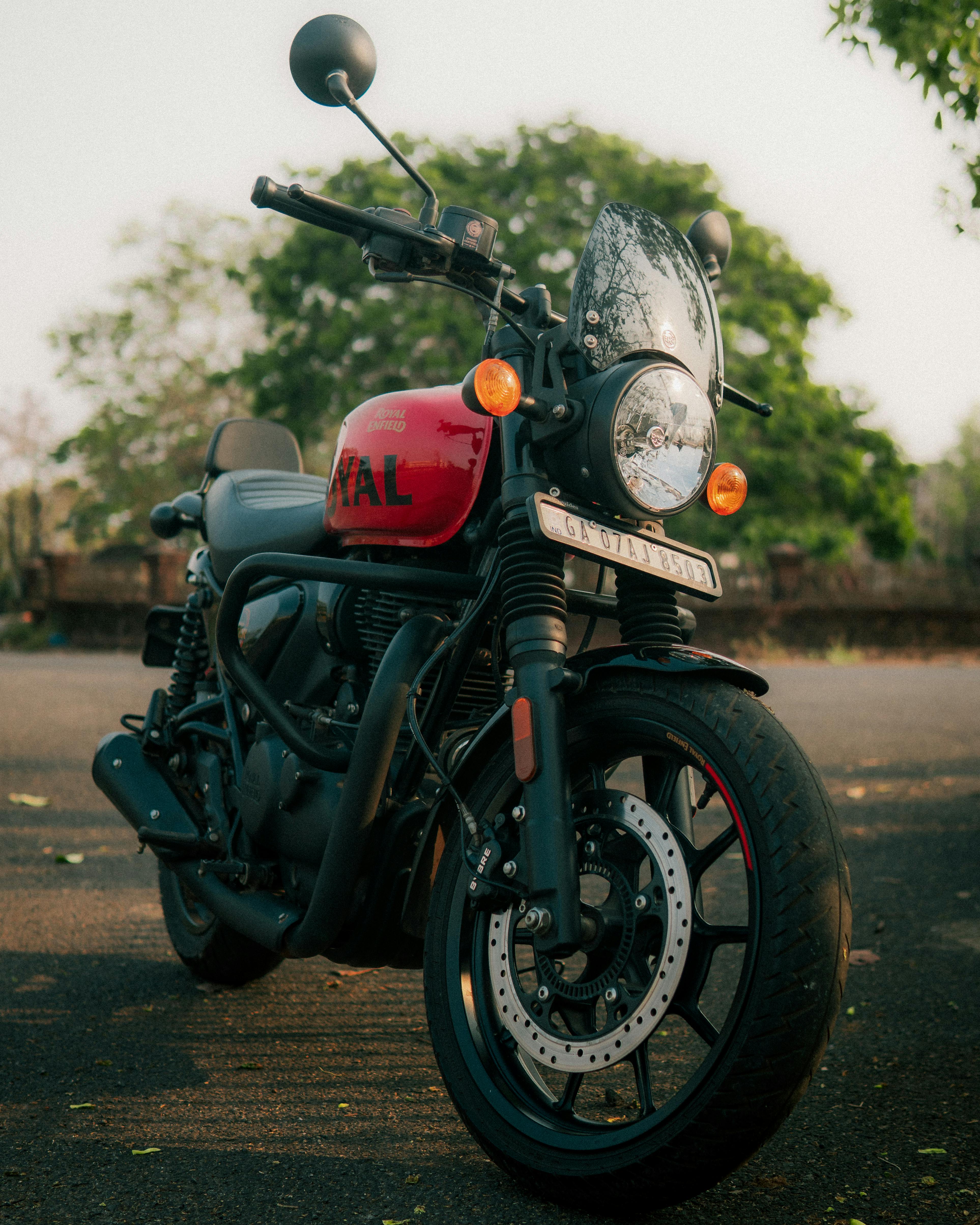 Free A vibrant red motorcycle with modern design elements parked in a scenic outdoor setting, capturing an adventurous spirit. Stock Photo