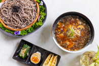 Delicious bowl of Asian noodles with side dishes, photographed from above.