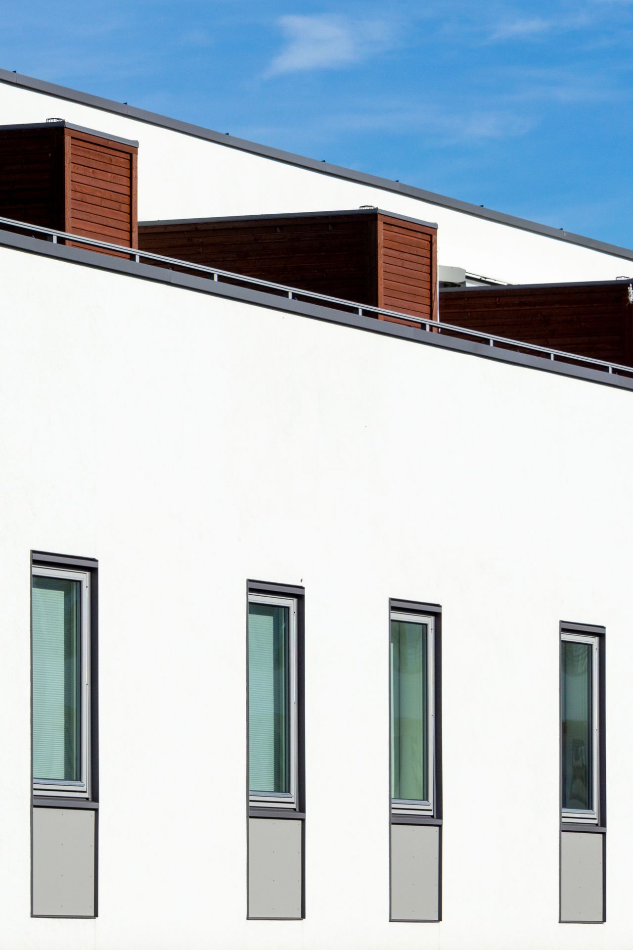 Modern white building with a flat roofline against a blue sky