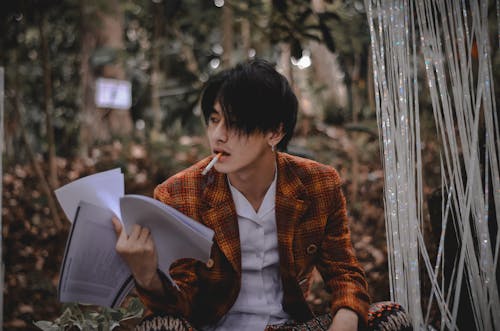 Фотография мужчины, курящего с бумагами