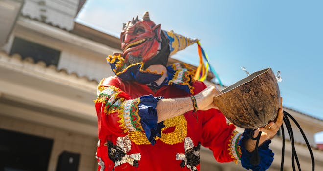 Colorful masked performer at a traditional festival in Rioja, San Martín, Peru, holding a ceremonial bowl.