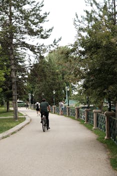 Bikers ride through a lush park path in Eskişehir, Türkiye, offering a scenic urban escape.