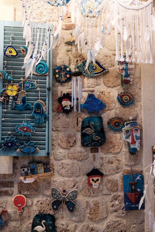 Free Vibrant Turkish pottery and crafts displayed on rustic stone wall in Side, Antalya. Stock Photo