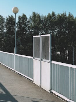 A serene walkway with a metal fence and trees in Ufa, Bashkortostan, Russia.