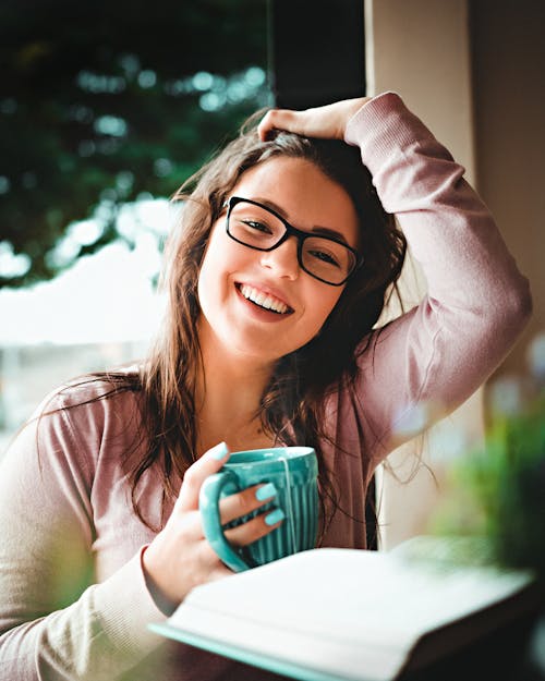 Donna Con Occhiali Incorniciati Neri Che Tiene Tazza Di Ceramica Verde