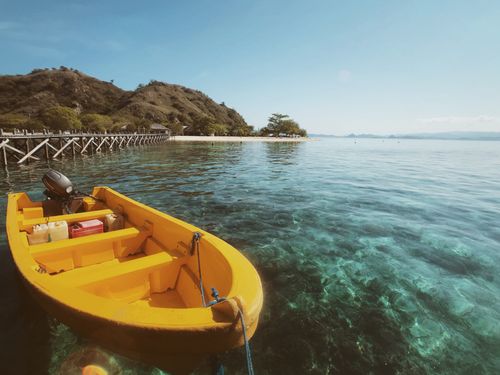 Free Yellow boat docked in clear waters of East Nusa Tenggara, showcasing serene Indonesian coastal landscape. Stock Photo
