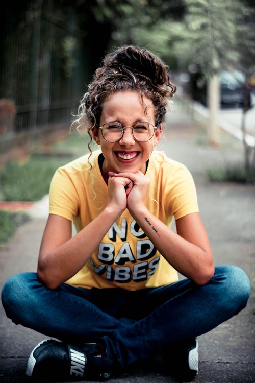 Girl Wearing Yellow Shirt Sitting on Gray Concrete Pavement