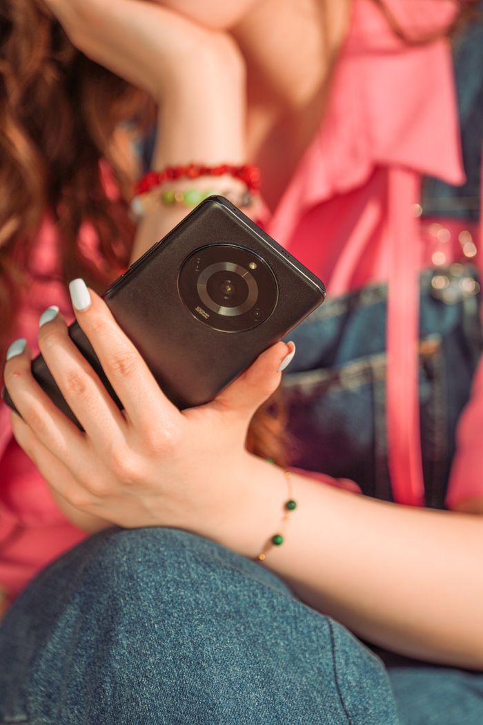 A creator holding a smartphone, close-up in denim — photo by khezez on Pexels