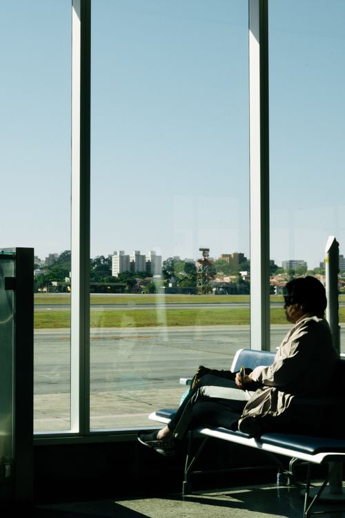 Free A person sitting in an airport terminal in São Paulo, Brazil, overlooking the runway. Stock Photo