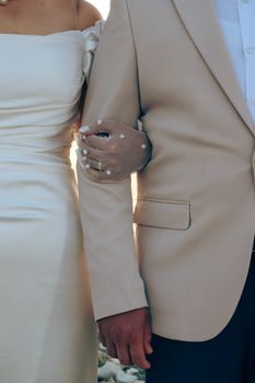 Close-up of a bride and groom in elegant clothes, showcasing wedding fashion detail.