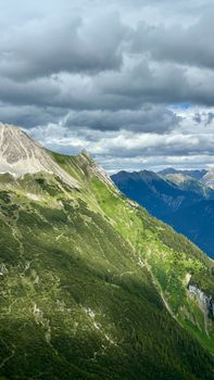 A stunning aerial shot of Hinterhornbach's lush green landscape in Tyrol, Austria, under a dramatic sky.