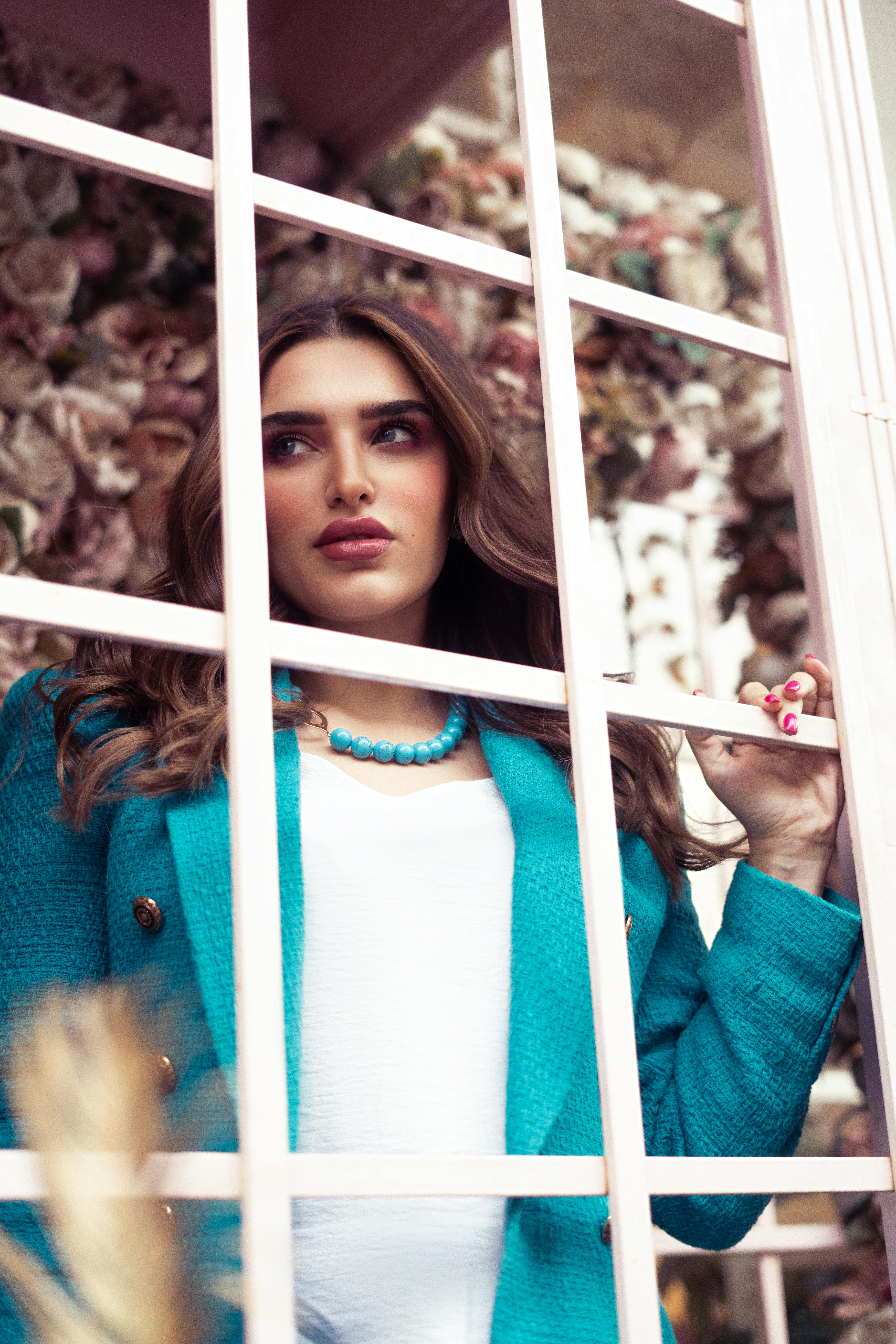 Free Portrait of an elegant woman in Baghdad, framed by a window, showcasing fashion and poise. Stock Photo