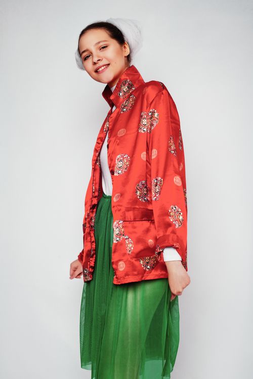 Free Elegant photoshoot of a woman wearing red satin and green dress, showcasing fashion in a studio. Stock Photo