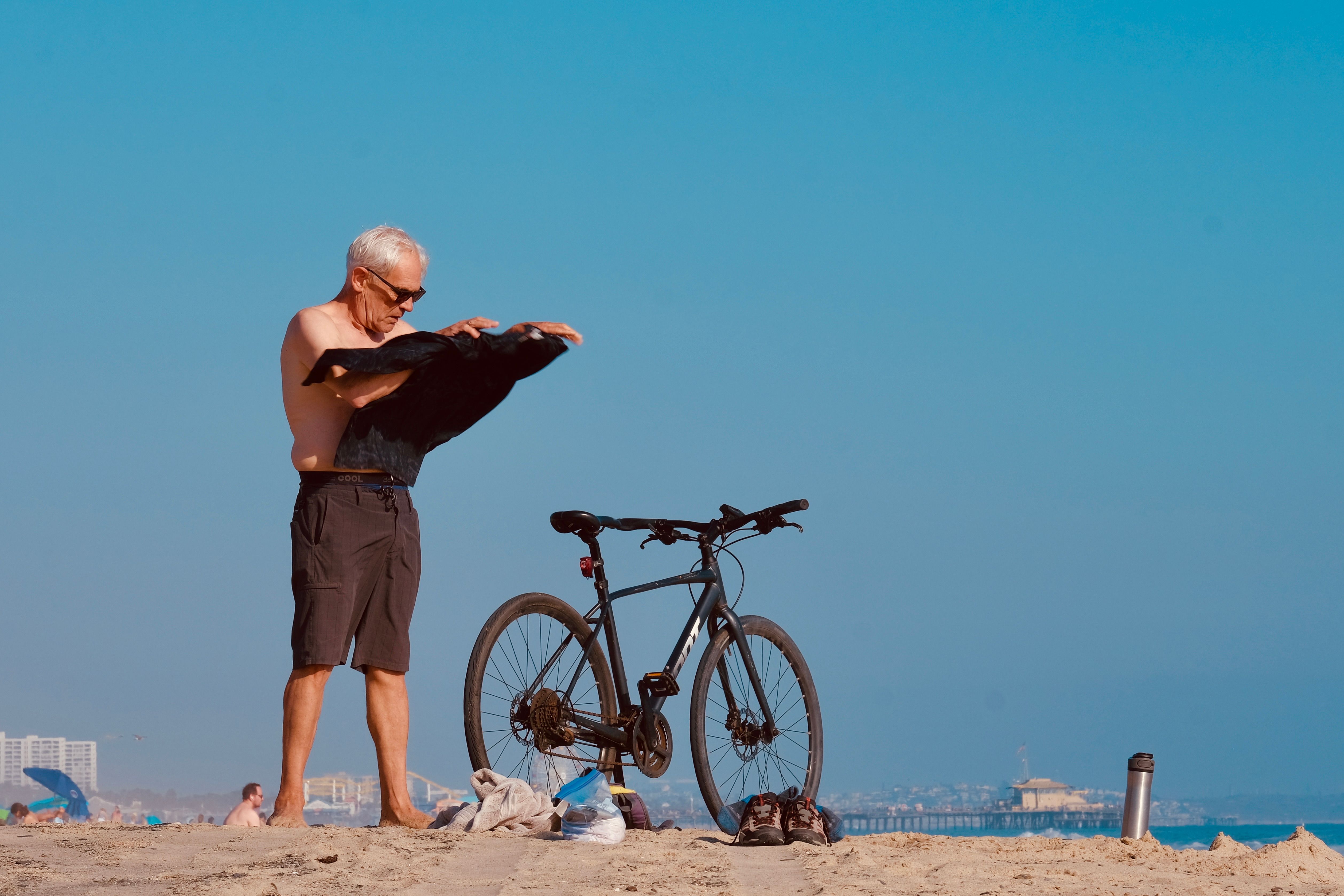 Senior Man Taking off Shirt on Beach · Free Stock Photo