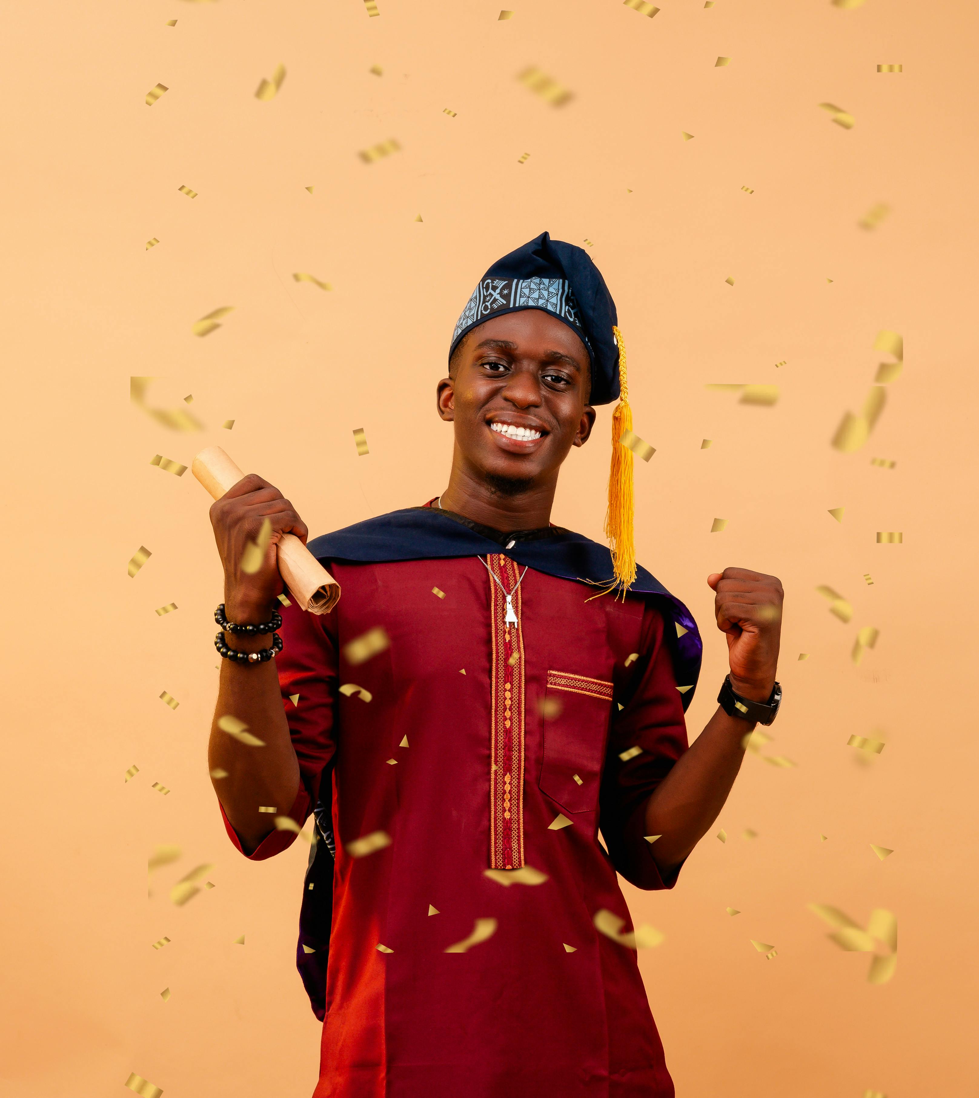 Nigerian graduate celebrating with a diploma, confetti, and traditional attire.