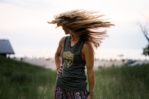 Free Woman outdoors flipping her hair in the wind, capturing a carefree summer vibe. Stock Photo