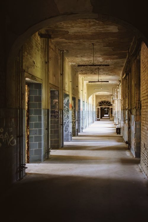 Free Explore a decaying, graffiti-filled corridor in the historic Beelitz hospital, Germany. Stock Photo