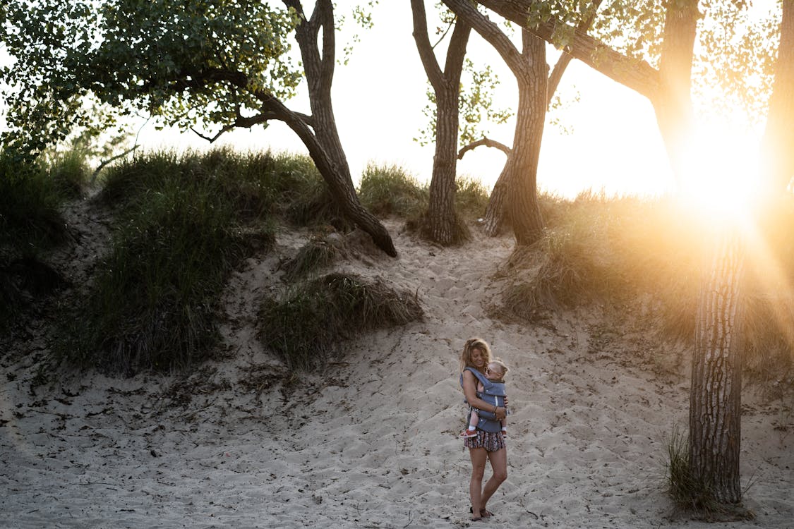 Woman Carrying Toddler Beside Trees