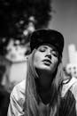 户外一位戴帽子的女性的艺术灰度肖像，带有一种忧郁的氛围