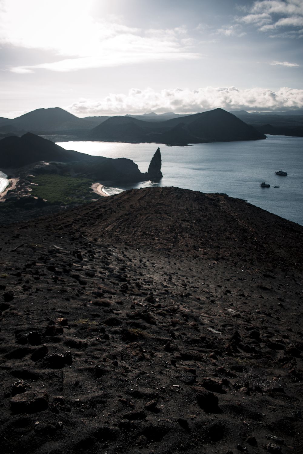 Pinnacle Rock en Isla Bartolomé, Galápagos, con paisaje volcánico al fondo
