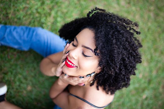 一位美丽的卷发女子涂着红色口红，在户外闭眼微笑摆着姿势