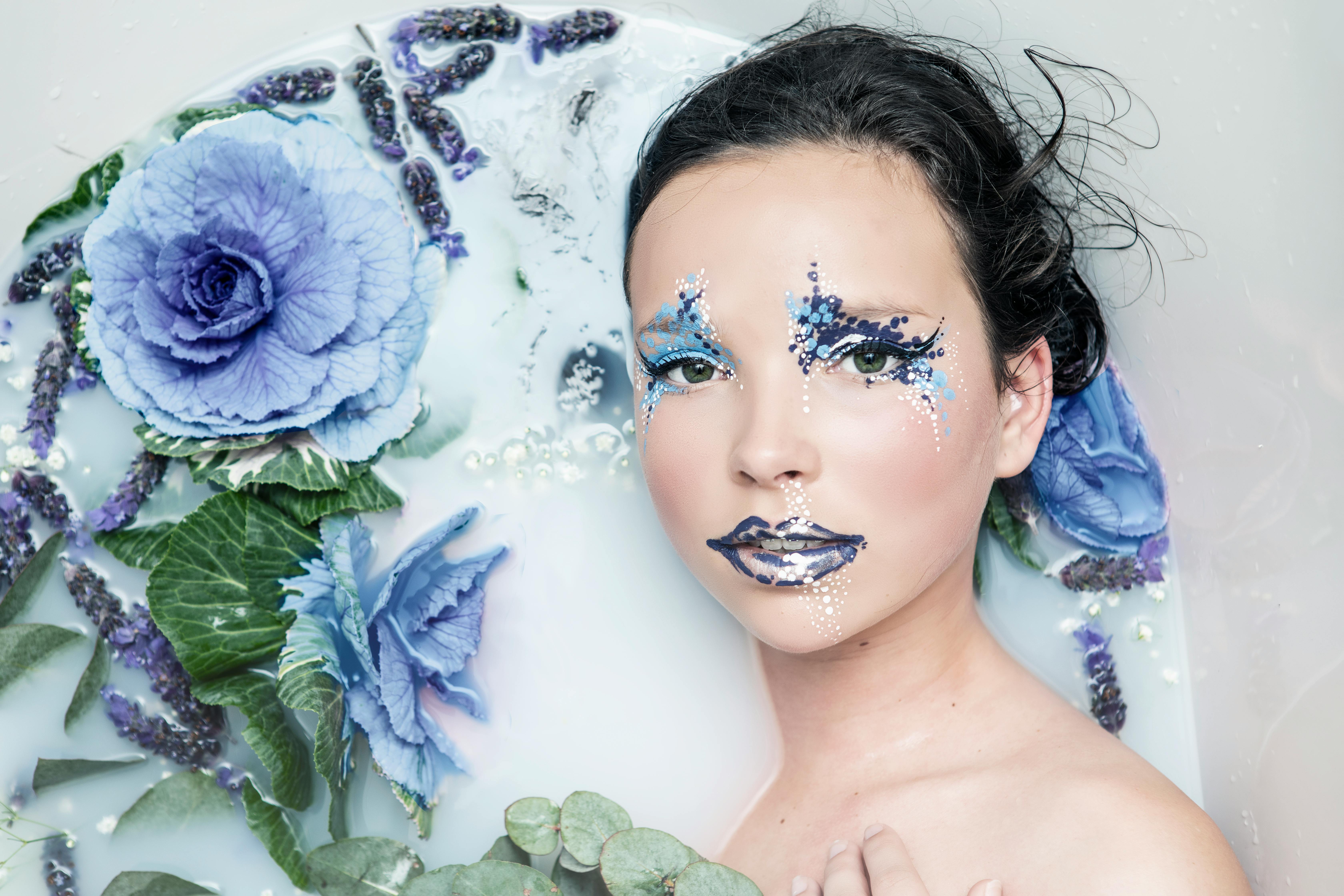 women near a blue flower close up photography