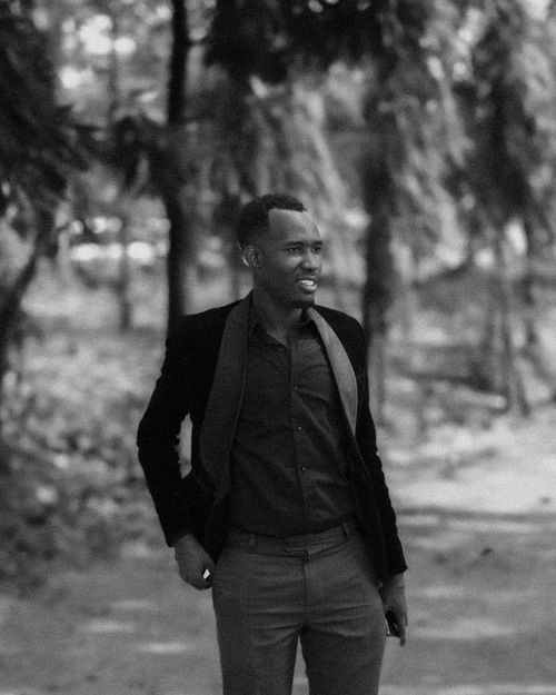 Free Black and white portrait of a fashionable man smiling outdoors. Stock Photo