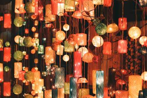 Free A vibrant display of various shaped and colored hanging lanterns illuminating a cozy indoor space. Stock Photo