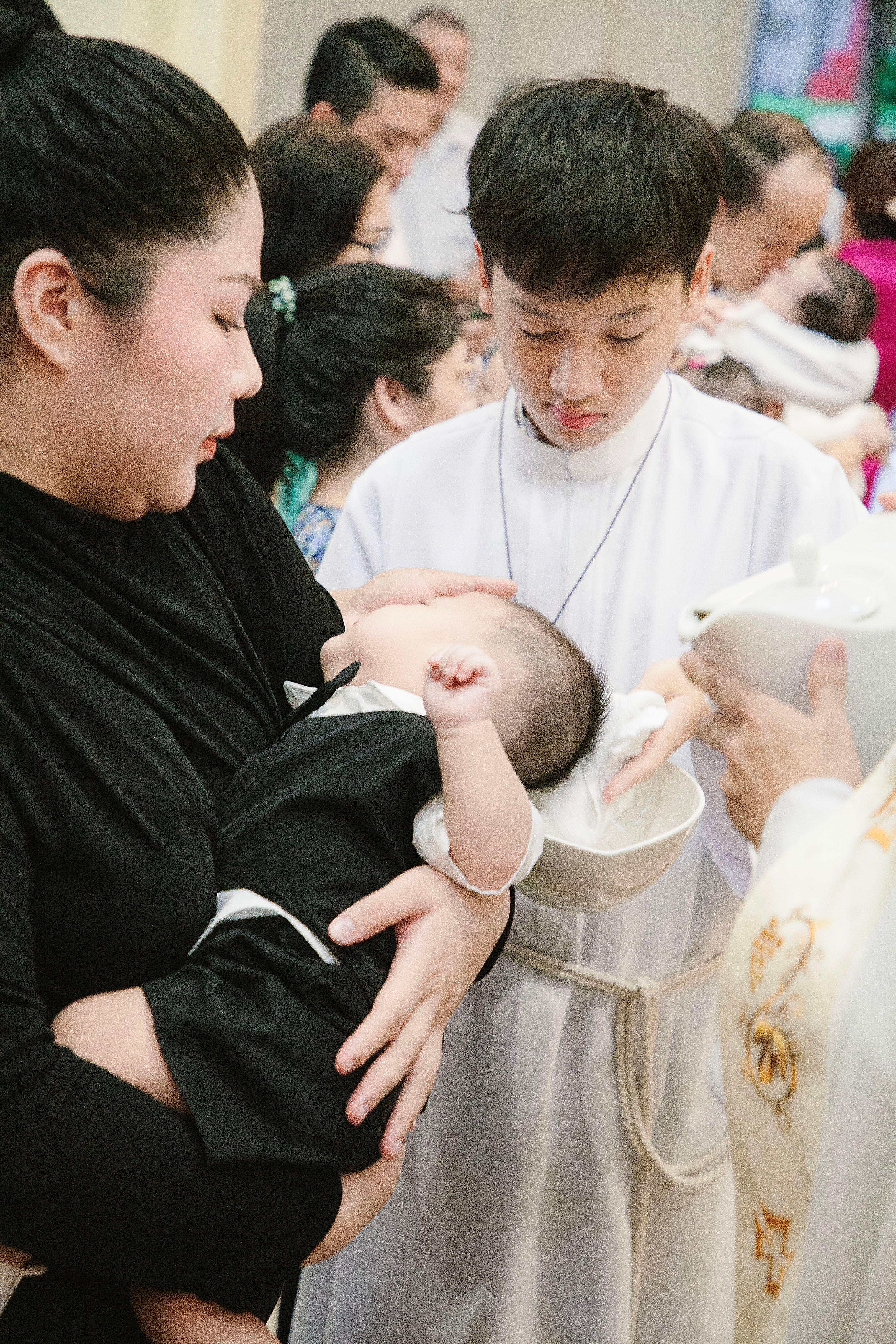 Mother Holding Baby in Baptism Ceremony · Free Stock Photo