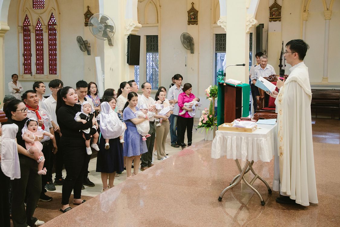 Parents Holding Their Babies While Participating In A Mass In A Church Parents Holding Their Babies While Participating In A Mass In A Church