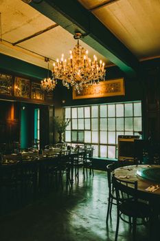 Charming vintage-style restaurant in Kuala Lumpur featuring chandeliers and classic wooden furniture.