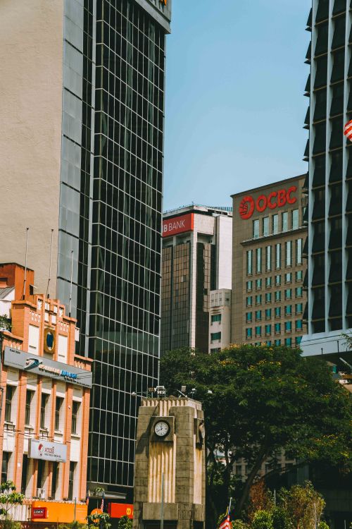 Free Urban cityscape of Kuala Lumpur featuring modern skyscrapers and a clock tower. Stock Photo