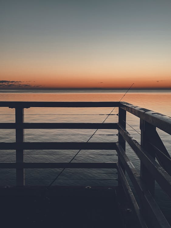 Free Fishing Rod Leaning on Wooden Rail Stock Photo