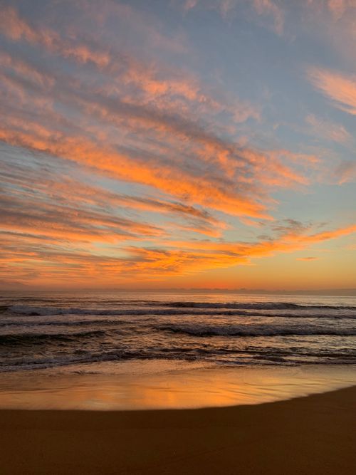 Free Captivating sunrise over the ocean with vibrant orange and pink skies. Stock Photo