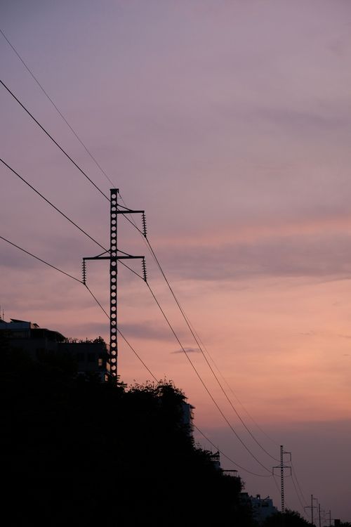 Free Silhouette of power lines with a pink sunset backdrop, creating a serene atmosphere. Stock Photo