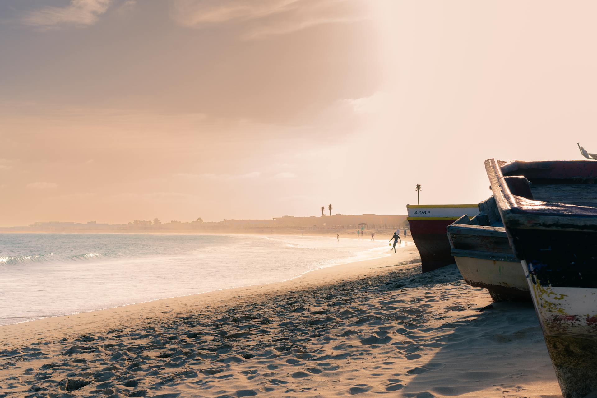 Tranquil sunset view of fishing boats on Sal Rei Beach, Boa Vista, Cabo Verde.