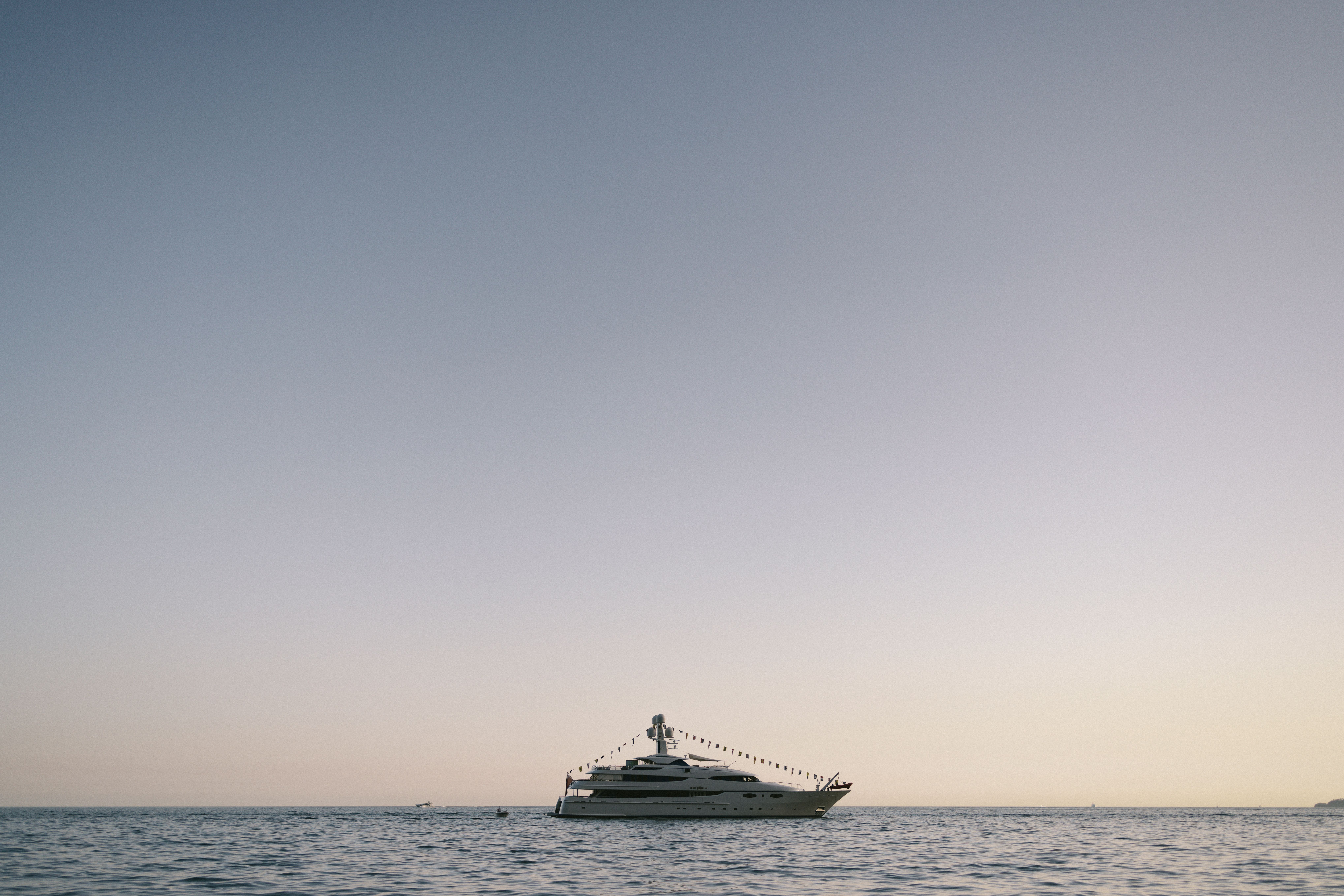 Luxury yacht anchored off the Malibu coastline at golden hour