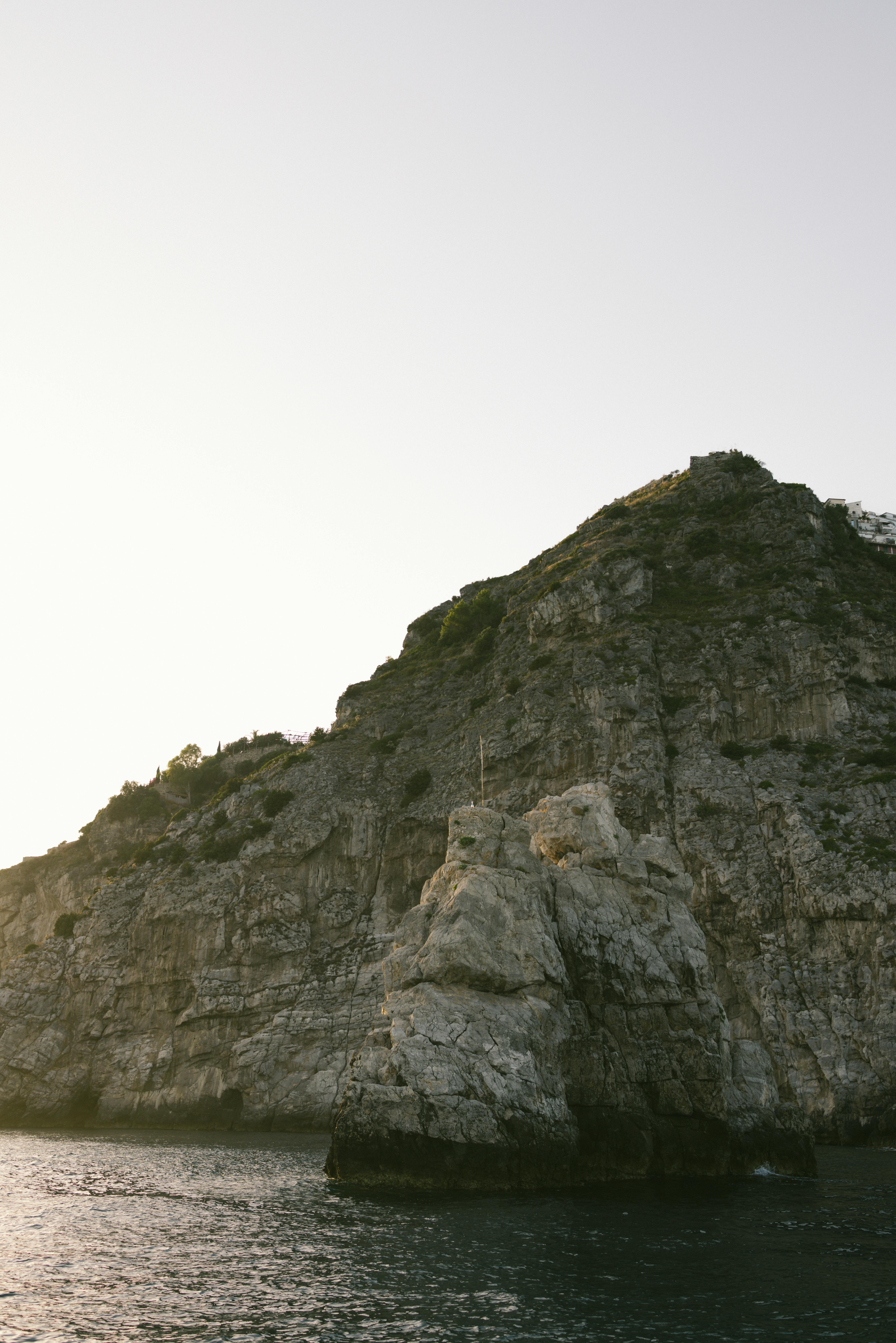 Dramatic cliffs at Positano's coastline with serene ocean view at sunrise.