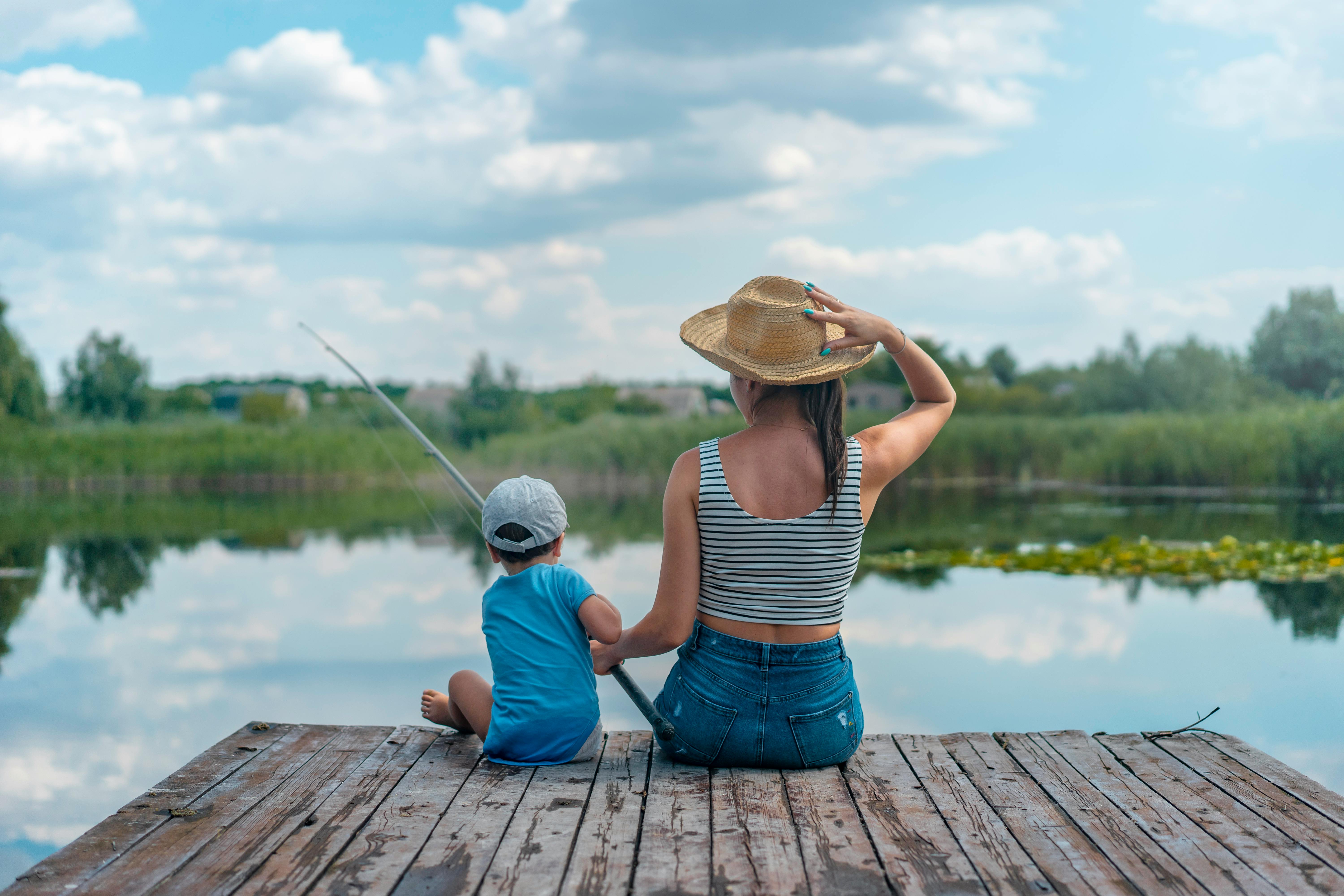 Woman and Boy Sitting on Dock Holding Fishing Rod · Free Stock Photo