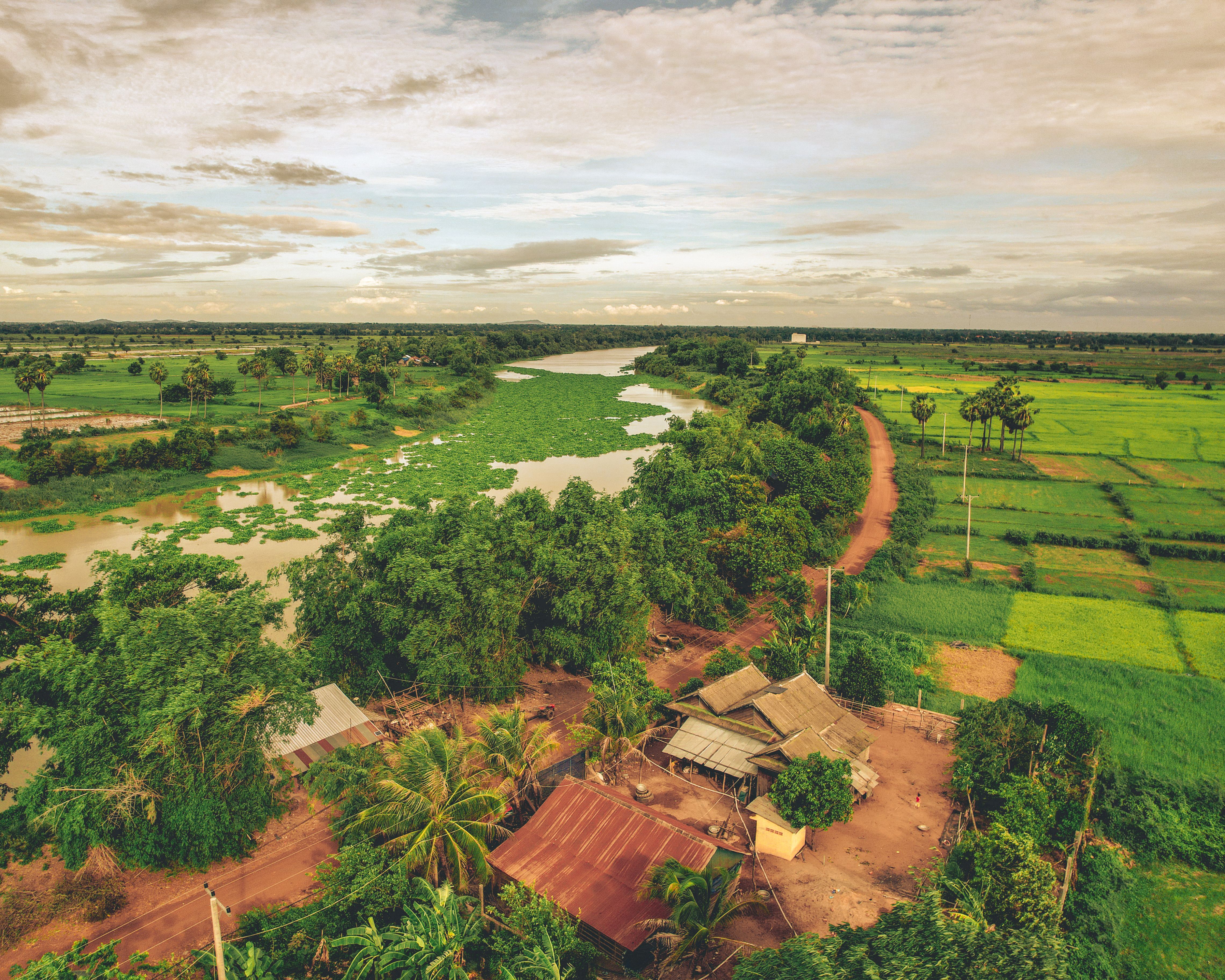 Aerial View of a Farm by the River Among Fields · Free Stock Photo