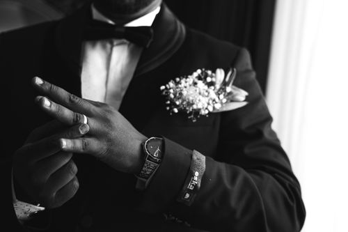 Free Elegant black and white portrait of a groom in formal attire showcasing a watch and wedding ring. Stock Photo