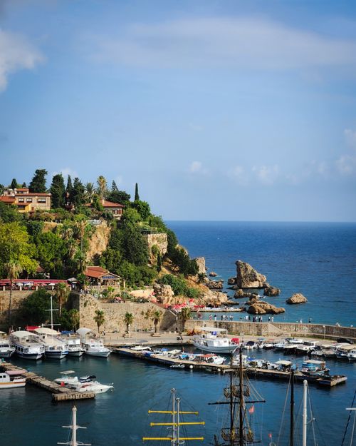 Free A beautiful seaside view of Antalya harbor with boats moored and green hills under a clear summer sky. Stock Photo