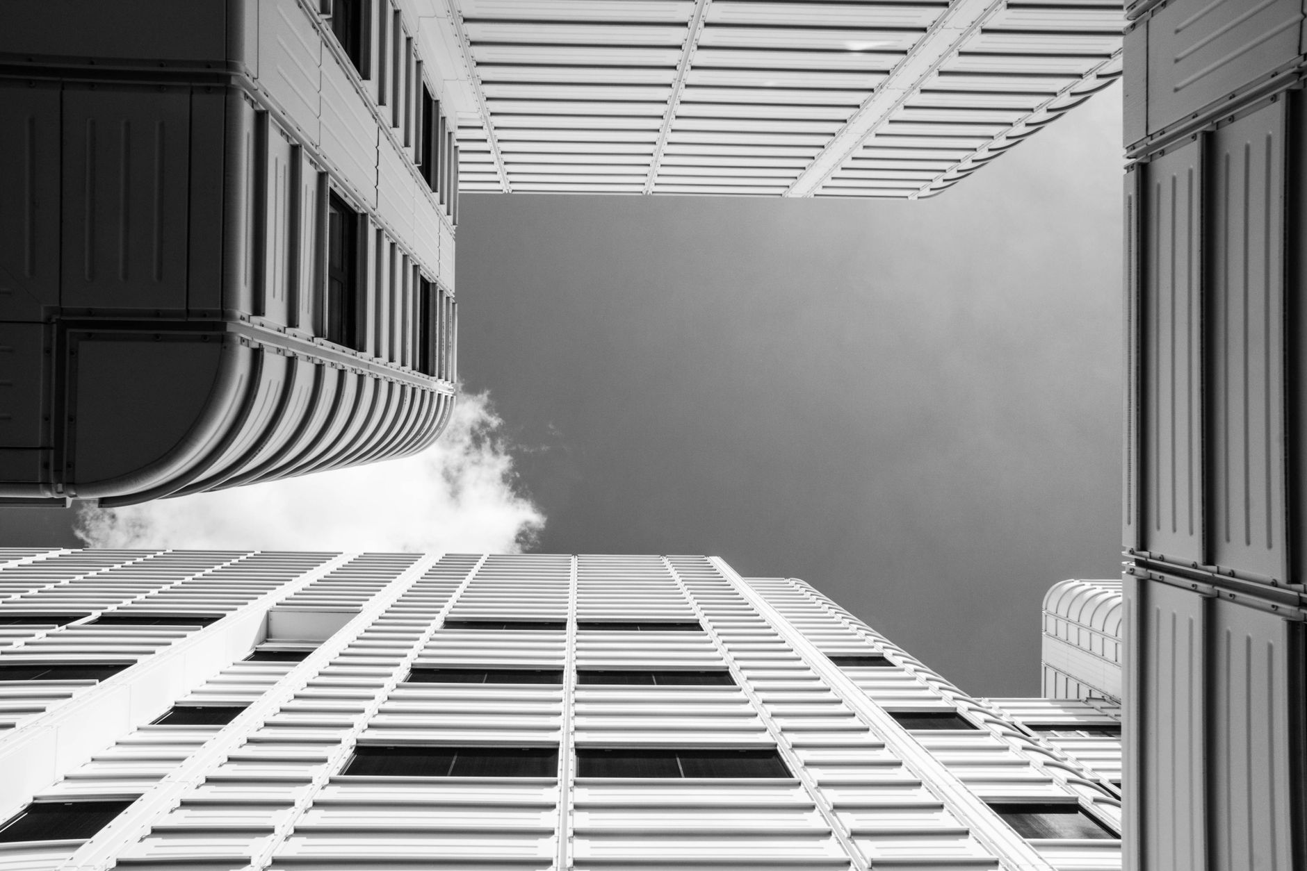 Black and white perspective of modern skyscrapers reaching towards the sky.