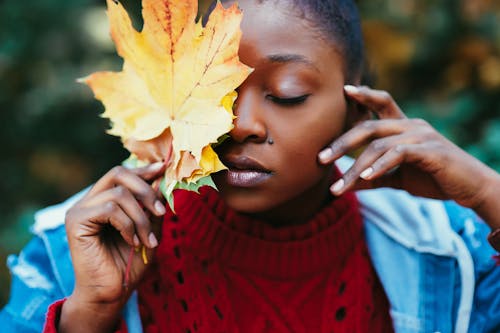 Selective Focus Photography of Woman Covering Face With Brown Leaf