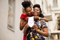 两名女性在户外愉快地庆祝医学毕业并领取了文凭